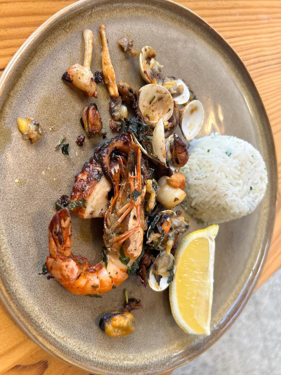 Gegrillter Oktopus, Garnelen, Venusmuscheln, Miesmuscheln und Jakobsmuschel, weißer Reis und Zitronenschnitz